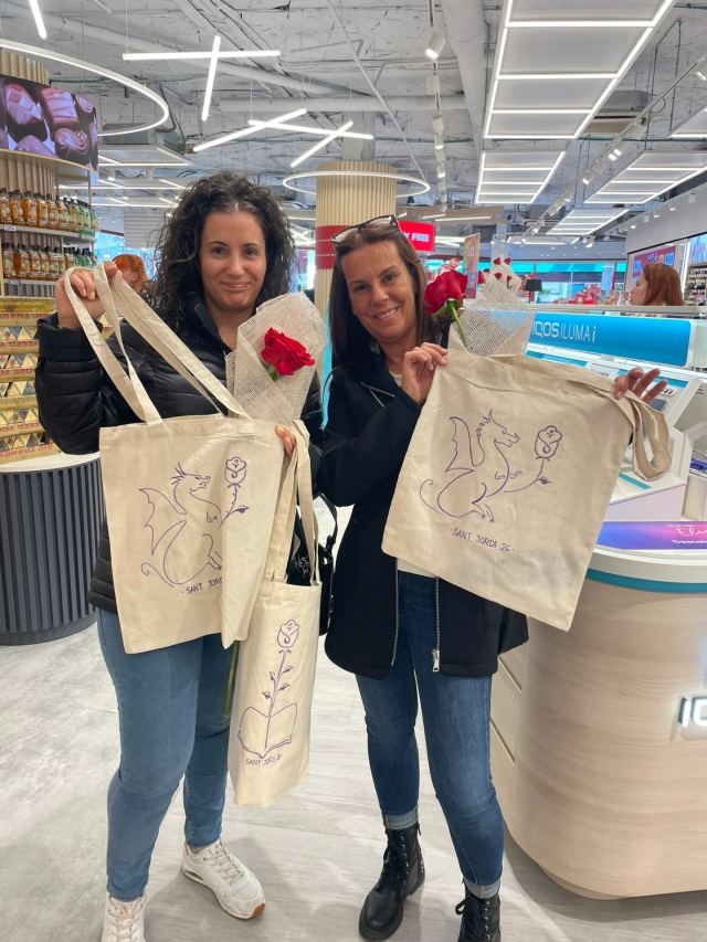 Clientes posando con su TotBag personalizada con ilutracion de sant Jordi