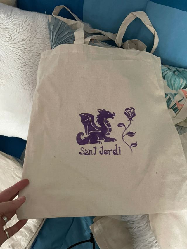Clientes posando con su TotBag personalizada con ilutracion de sant Jordi